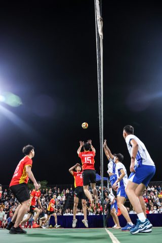 Des joueurs participent à un match de volley-ball au niveau de village à Wenchang