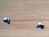 Des agriculteurs épandent de l'engrais sur un champs de blé