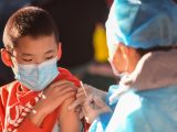 Un garçon reçoit une dose de vaccin de COVID-19 dans une école à Hohhot