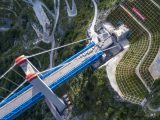 Photo aérienne prise le 26 juillet 2022 montrant le grand pont de la rivière Jinsha au niveau de sa jonction avec l'entrée du tunnel du mont enneigé Haba sur la ligne du chemin de fer Lijiang-Shangri-La dans la province du Yunnan (sud-ouest)