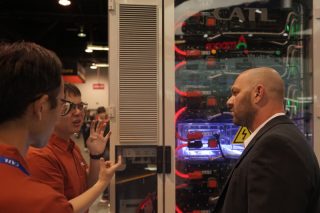 Un membre du personnel discute avec un visiteur dans la zone d'exposition de l'entreprise chinoise CATL lors de l'exposition RE+ 2024 à Anahiem