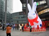 Des gens posent pour des photos avec un lapin gonflable géant devant un centre commercial de Changsha