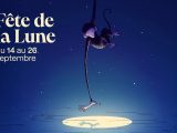Affiche de la fête : sur un ciel bleu nuit étoilé, un singe dessiné au trait pend par sa longue queue, la tête en bas, et tend la patte vers le disque blanc de la lune qui se reflète sur une eau striée de traits