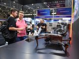 Des visiteurs devant le stand d'exposition d'une société de drones lors de la 26e Foire des hautes technologies de Chine à Shenzhen