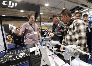 Des gens visitent le stand du fabricant chinois de drones DJI à l'Expo ProFusion 2024 à Toronto
