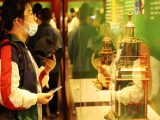 Des touristes visitent une exposition présentant des reliques restaurées au Musée du Palais de Shenyang