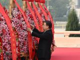 Xi Jinping redresse le ruban rouge d'une corbeille de fleurs lors d'une cérémonie de dépôt de corbeilles de fleurs aux héros nationaux tombés au combat