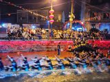 Des personnes participent à une course de bateaux-dragons nocturne à l'occasion de la fête traditionnelle des bateaux-dragons à venir dans le village de Sanxi