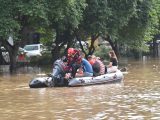 Des secouristes aident des habitants locaux à évacuer une route inondée à Guilin
