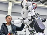 Un chercheur ajuste un robot humanoïde dans un laboratoire d'intelligence artificielle le 31 janvier 2024
