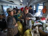 Une femme de l'ethnie Yi vend des marchandises dans un marché ambulant à bord du train 5633 dans la province du Sichuan (sud-ouest de la Chine)