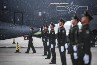 Des soldats escortent des cercueils contenant des dépouilles de martyrs des Volontaires du peuple chinois (VPC) à l'Aéroport international de Taoxian