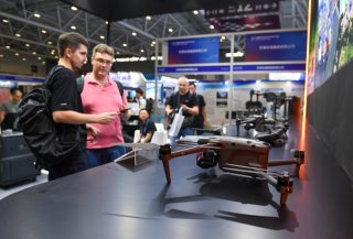 Des visiteurs devant le stand d'exposition d'une société de drones lors de la 26e Foire des hautes technologies de Chine à Shenzhen
