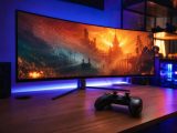 Écran d'ordinateur affichant un jeu vidéo dans une pièce sombre, avec une manette posée au premier plan