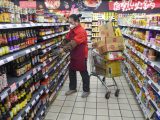 Une employée met des marchandises en rayon dans un supermarché de l'arrondissement de Tianshan