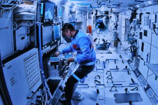 Image d'écran capturée au Centre de contrôle aérospatial de Beijing montrant l'astronaute de Shenzhou-17 Jiang Xinlin à l'intérieur du module laboratoire coopérant avec Tang Hongbo et Tang Shengjie pour leurs activités extravéhiculaires