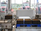 Des bras robotiques empilent des bacs de semis de riz sur une chaîne de montage d'une base de démonstration de riziculture intelligente du bourg de Gongyi