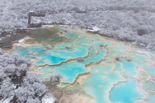 Un ensemble d'étangs colorés dans le site touristique de Huanglong recouvert de neige