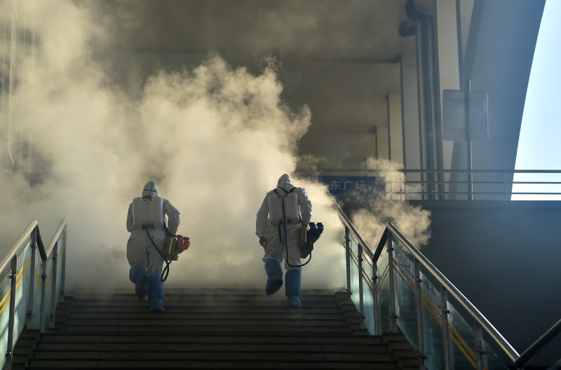 Des membres du personnel désinfectent la place ouest de la gare de Shijiazhuang