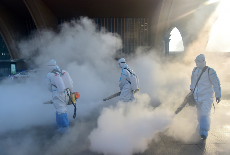 Des membres du personnel désinfectent la place ouest de la gare de Shijiazhuang