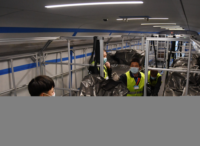 Des travailleurs chargent des colis sur un train à grande vitesse Fuxing à la Gare de l'ouest de Beijing à Beijing