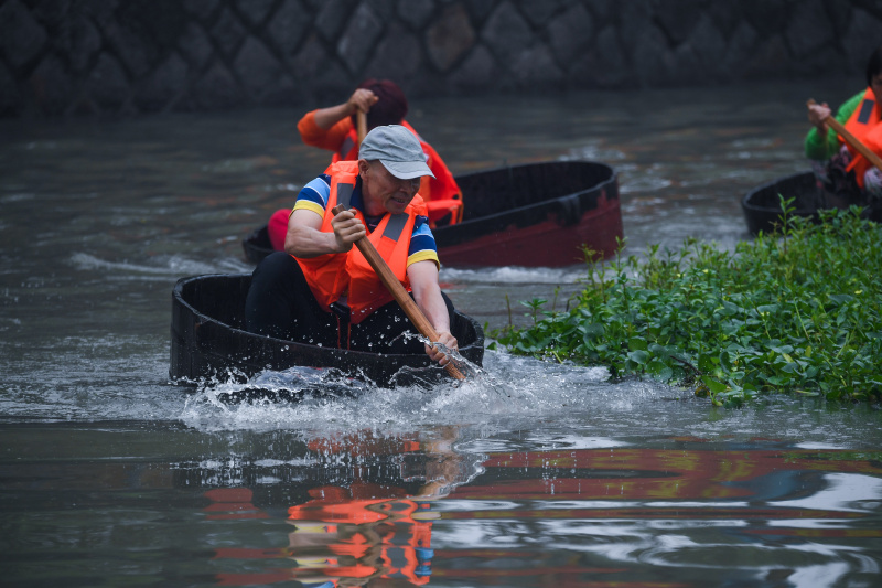 Des villageois participent à une compétition d'aviron de seau au village de Quanxin de la ville de Huzhou