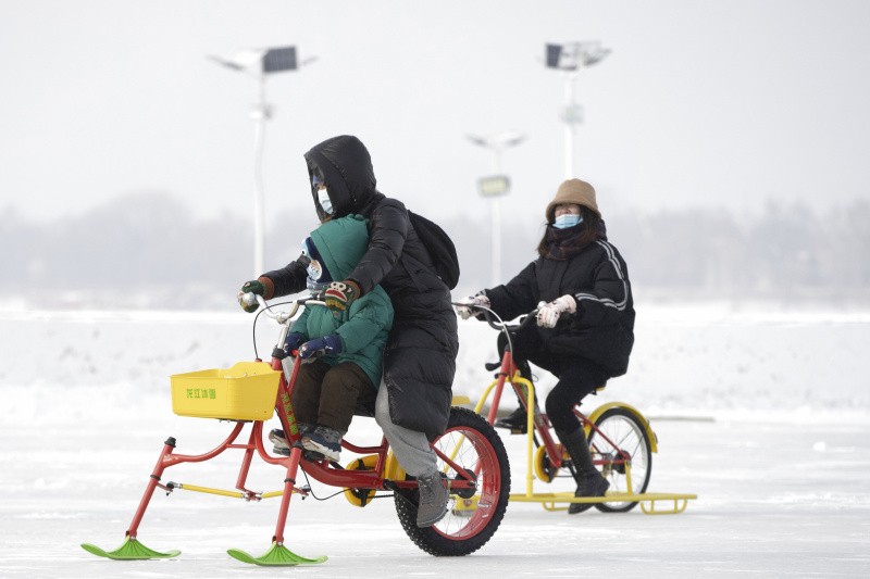 Des touristes s'amusent sur le fleuve Songhua gelé dans un parc d'attractions de neige et de glace à Harbin