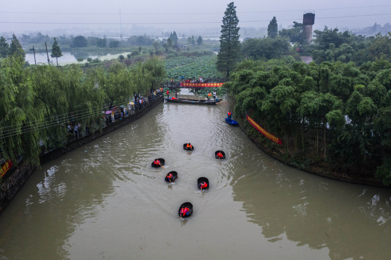 Des villageois participent à une compétition d'aviron de seau au village de Quanxin de la ville de Huzhou