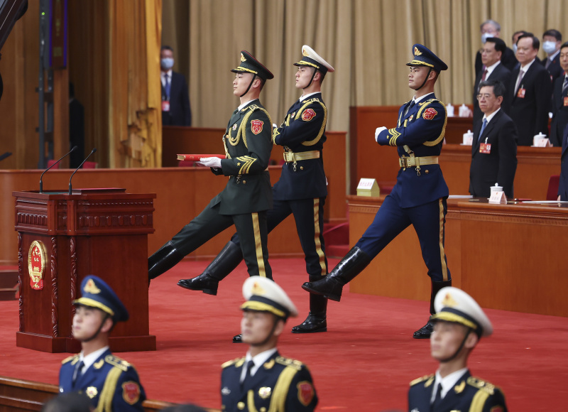 La garde d'honneur de l'Armée populaire de libération (APL) de la Chine porte un exemplaire de la Constitution du pays lors de la cérémonie d'allégeance à la Constitution chinoise pour les dirigeants nouvellement élus du pays qui se déroule au Grand Palais du Peuple