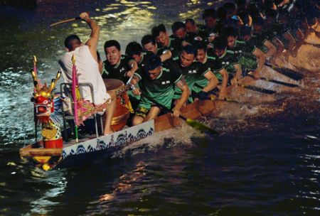(miniature) Des personnes participent à une course de bateaux-dragons nocturne à l'occasion de la fête traditionnelle des bateaux-dragons à venir dans le village de Sanxi