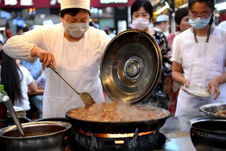 (miniature) Un vendeur cuisine des plats traditionnels au march&eacute; de nuit de la tour du Tambour &agrave; Kaifeng