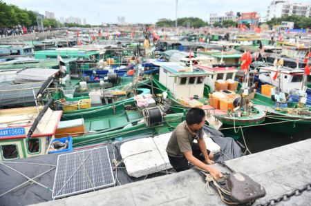 (miniature) Un pêcheur quitte son bateau dans le port de Dianjian