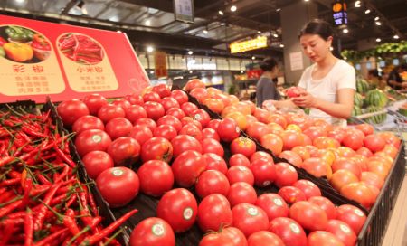 (miniature) Une cliente sélectionne des tomates dans un supermarché de la ville de Linyi