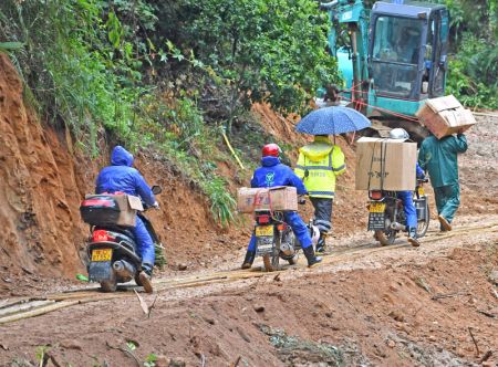 (miniature) Des motocyclistes volontaires aident à transporter des fournitures de secours vers le site du récent crash aérien