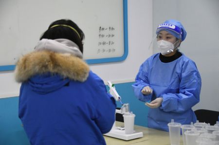 (miniature) Un professionnel médical prépare une dose de vaccin inhalable contre la COVID-19 sur un site de vaccination