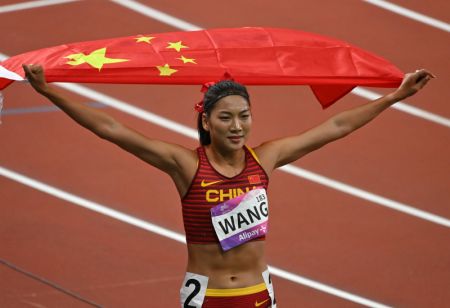 (miniature) La Chinoise Wang Chunyu brandit le drapeau chinois après la finale du 800m femmes aux 19es Jeux asiatiques à Hangzhou
