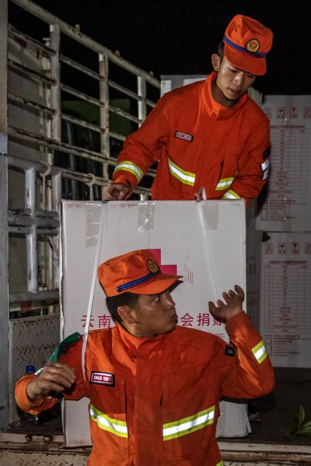 (miniature) Des secouristes transportent du matériel de secours à Yangbi