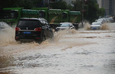 (miniature) Des véhicules traversent une route inondée à Hezhou