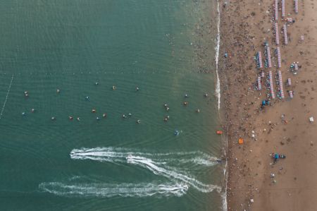 (miniature) Photo aérienne de touristes s'amusant au bord de la mer