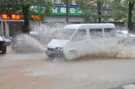 (miniature) Une voiture traverse une rue détrempée dans le bourg de Pan'an de la ville de Jinhua