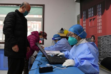 (miniature) Le personnel médical enregistre les informations des résidents avant qu'ils ne reçoivent l'injection de rappel du vaccin contre la COVID-19 sur un site de vaccination temporaire à Beijing