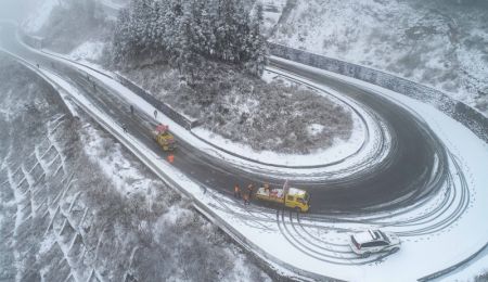 (miniature) Des travailleurs nettoient la neige sur une autoroute à Panshi