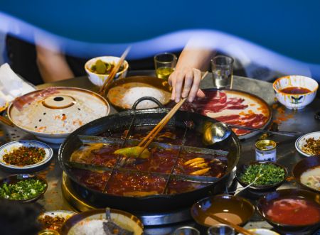 (miniature) Des gens dînent dans un restaurant de fondue chinoise dans une rue commerciale de la municipalité de Chongqing