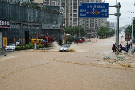 (miniature) Un véhicule emprunte une route inondée du district de Shexian