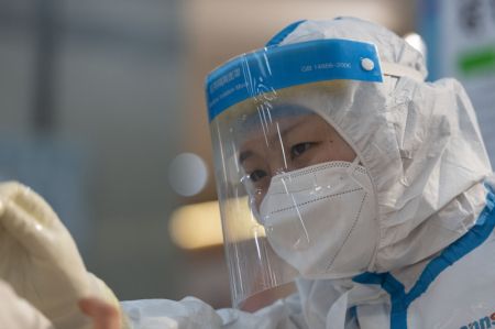 (miniature) Un travailleur m&eacute;dical pr&eacute;l&egrave;ve un &eacute;chantillon d'acide nucl&eacute;ique sur un site de d&eacute;pistage &agrave; Harbin