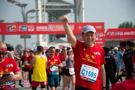 (miniature) Un participant pose pour une photo après le Semi-Marathon de Beijing