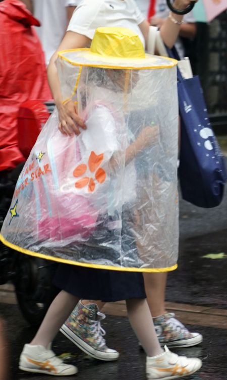 (miniature) Un élève portant un imperméable quitte une école primaire dans l'arrondissement de Huangpu