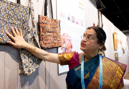 (miniature) Une artiste indienne présente des sacs réalisés à la main