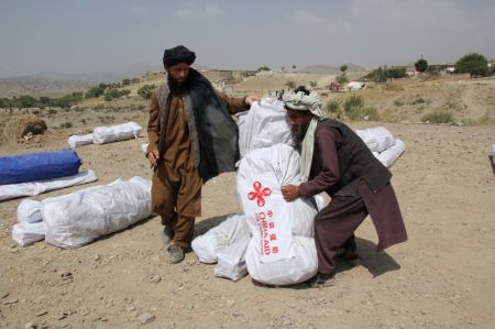 (miniature) Photo prise le 2 juillet 2022 montrant des Afghans transportant des fournitures de secours pour le tremblement de terre données par la Chine dans la province afghane de Paktika (est)