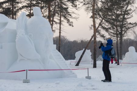 (miniature) Un visiteur prend des photos lors de la 33e Exposition internationale d'art de sculpture sur neige de Harbin